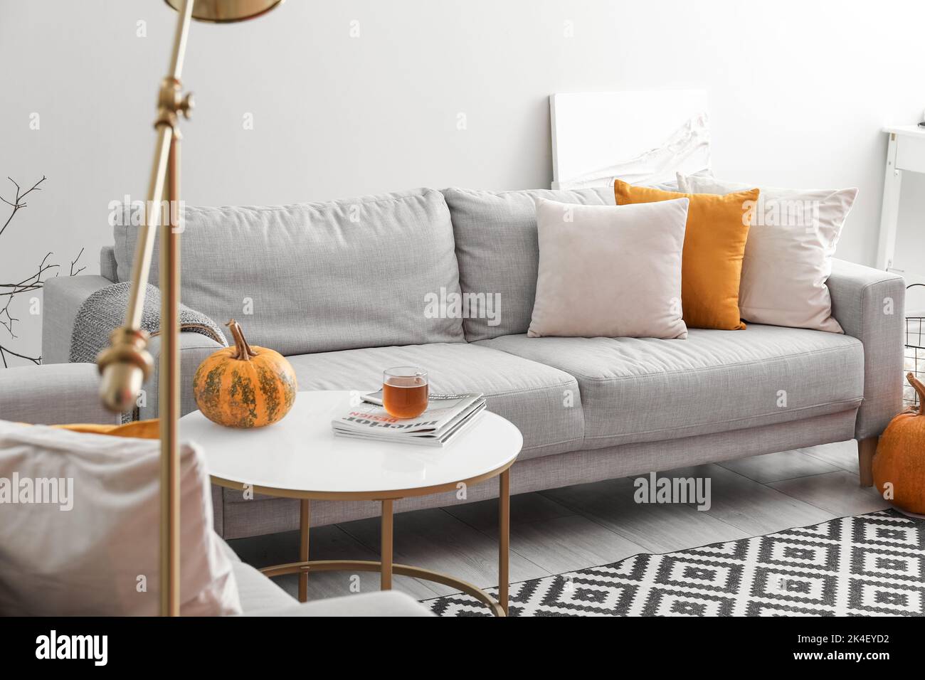 Autumn interior of living room with grey sofa and table Stock Photo - Alamy
