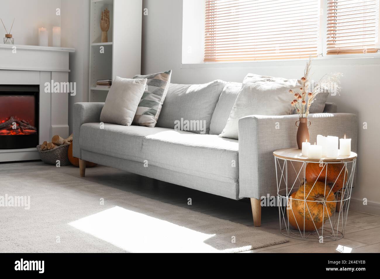 Interior of living room with grey sofa, table and fireplace Stock Photo ...