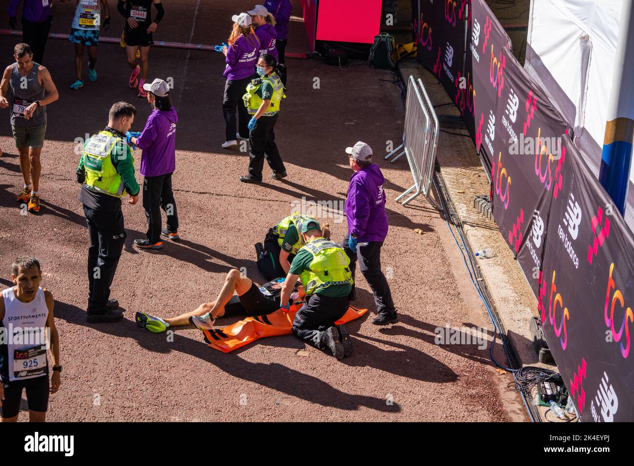 London UK. 2 October 2022 . A marathon runner  is attended  by paramedics after crossing the finishing line at The Mall .More than  40,000 athletes including  elite  runners, club runners and fun runners   take  part in the London Marathon sponsored by TCS Tata Consultancy Services over a 26.2 mile course.Credit: amer ghazzal/Alamy Live News. Stock Photo