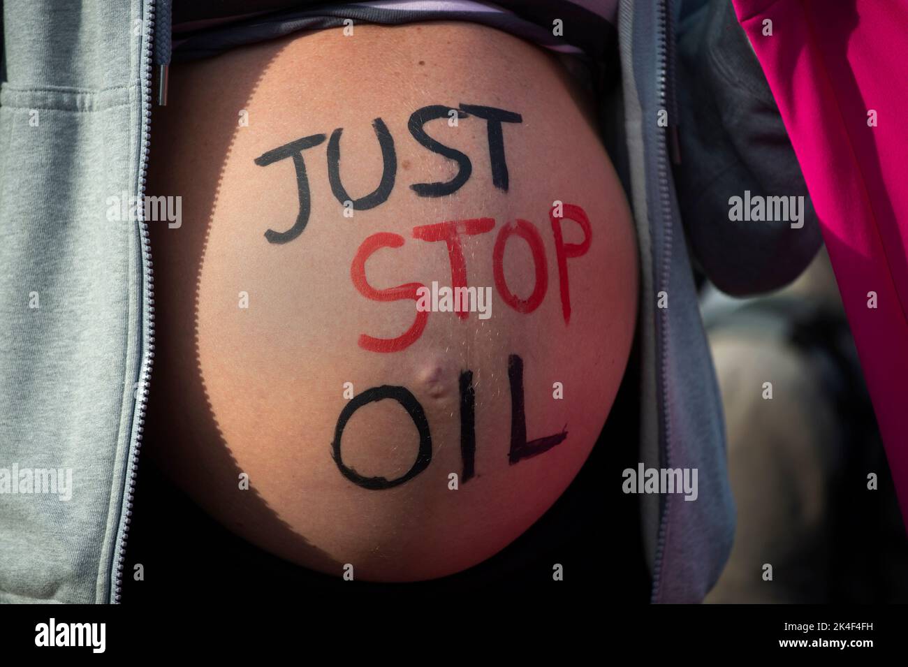 London. People protest against the oil industry and the cost of living crisis. A Pregnant woman with 'Just stop oil' written on her belly, holds a ban Stock Photo