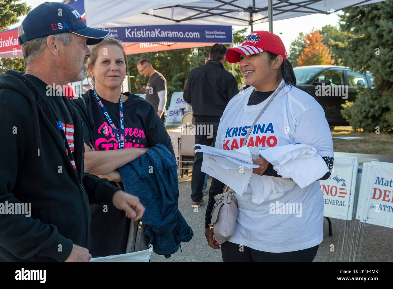 Warren, Michigan, USA. 1st Oct, 2022. Michele Haroon, a volunteer supporting Kristina Karamo, who is the Republican candidate for Michigan Secretary of State, talks with people arriving for a Donald Trump rally. Trump is supporting Tudor Dixon, Matt DePerno, and Kristina Karamo, Republican candidates for (respectively) Michigan governor, attorney general, and secretary of state. Credit: Jim West/Alamy Live News Stock Photo
