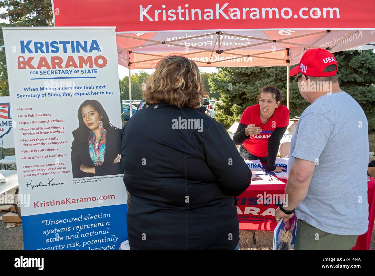 Warren, Michigan, USA. 1st Oct, 2022. A supporter of Kristina Karamo, who is the Republican candidate for Michigan Secretary of State, campaigns outside a Donald Trump rally. Trump is supporting Tudor Dixon, Matt DePerno, and Kristina Karamo, Republican candidates for (respectively) Michigan governor, attorney general, and secretary of state. Credit: Jim West/Alamy Live News Stock Photo