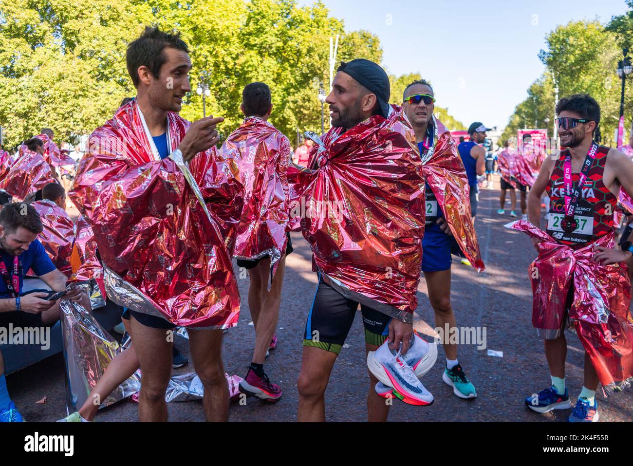 London UK. 2 October 2022 .  Marathon runners  are wrapped in a  foil blanket after crossing  the finishing line at The Mall More than  40,000 athletes including  elite  runners, club runners and fun runners   take  part in the London Marathon sponsored by TCS Tata Consultancy Services over a 26.2 mile course.Credit: amer ghazzal/Alamy Live News. Stock Photo