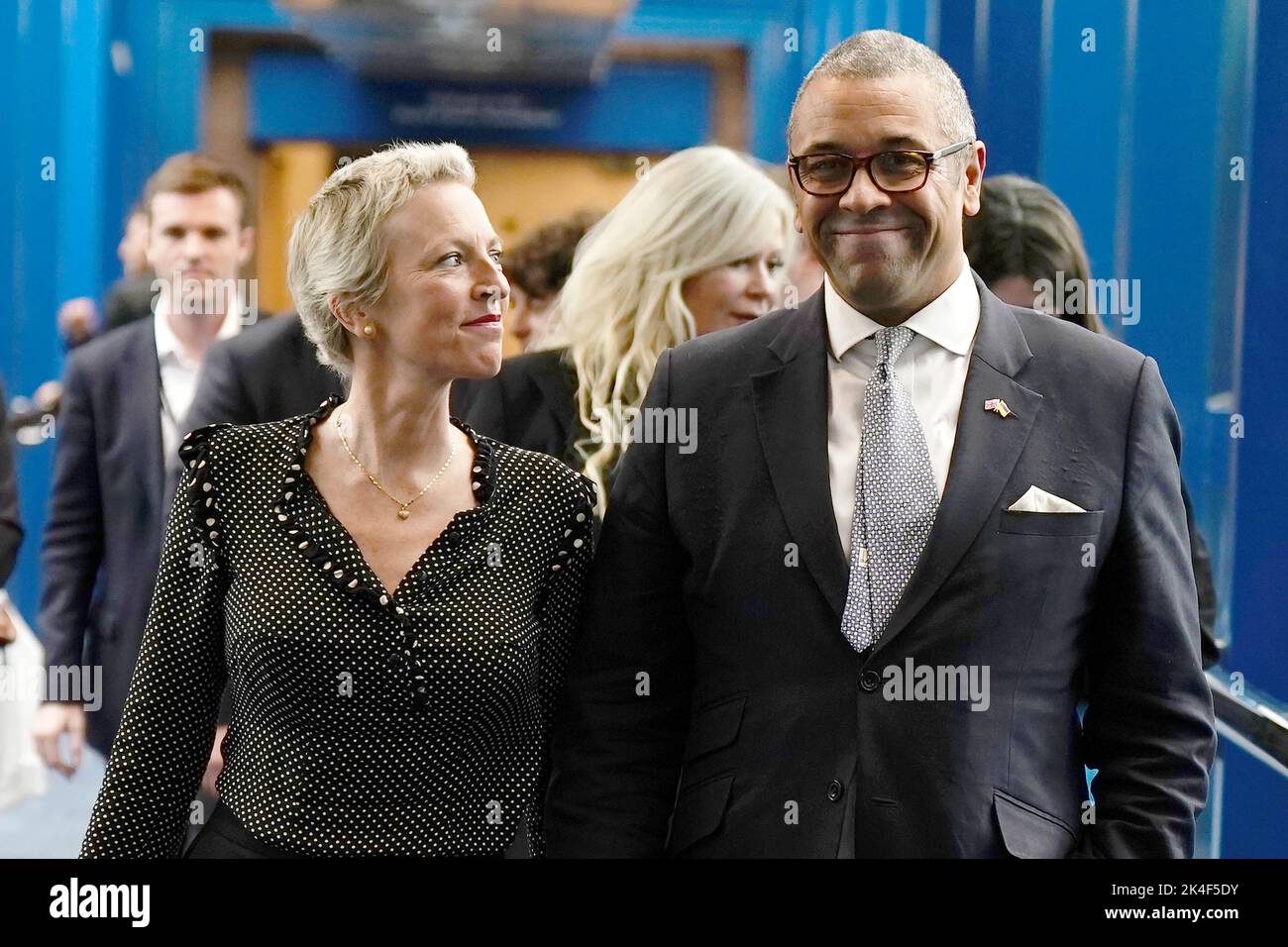 Foreign Secretary James Cleverly walks with his wife, Susannah Janet Temple Cleverly, across the Hyatt hotel bridge at the Conservative Party annual conference at the International Convention Centre in Birmingham. Picture date: Sunday October 2, 2022. Stock Photo
