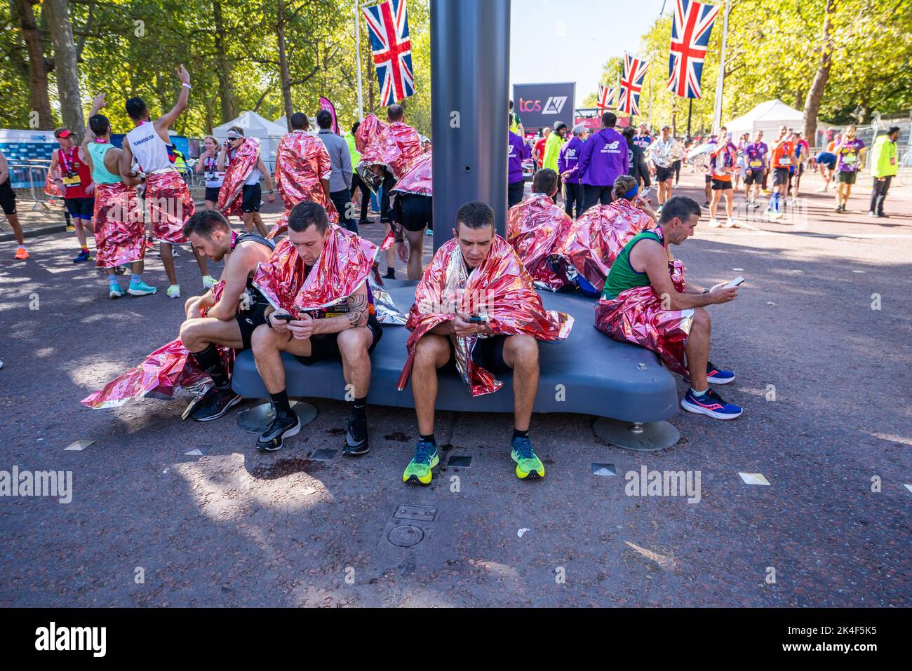 London UK. 2 October 2022 .  Marathon runners  are wrapped in a  foil blanket after crossing  the finishing line at The Mall More than  40,000 athletes including  elite  runners, club runners and fun runners   take  part in the London Marathon sponsored by TCS Tata Consultancy Services over a 26.2 mile course.Credit: amer ghazzal/Alamy Live News. Stock Photo