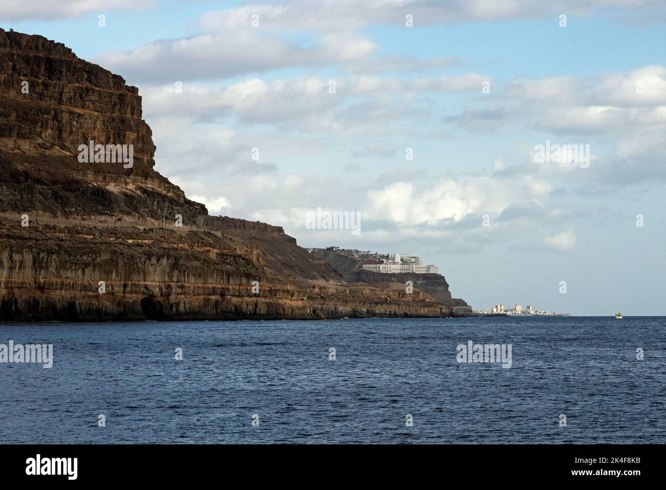 Puerto Mogan, Gran Canary, former fishing village turned tourist trap. View from the harbour via Amadore Beach all the way to Maspalomas. Stock Photo