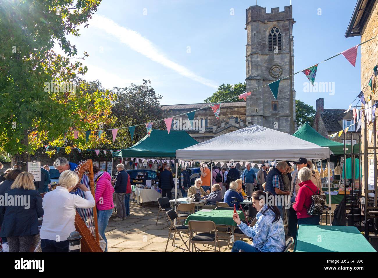 Harpist playing in Eynsham Country Market, Market Square, Eynsham, Oxfordshire, England, United Kingdom Stock Photo