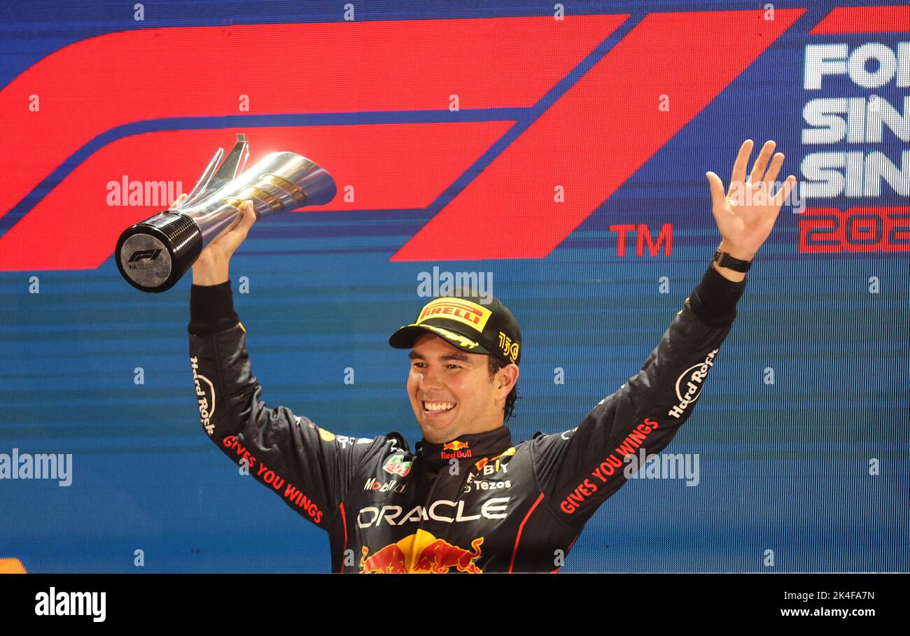 Formula One F1 - Singapore Grand Prix - Marina Bay Street Circuit, Singapore - October 2, 2022 Red Bull's Sergio Perez celebrates with the trophy on the podium after winning the Singapore Grand Prix REUTERS/Edgar Su Stock Photo