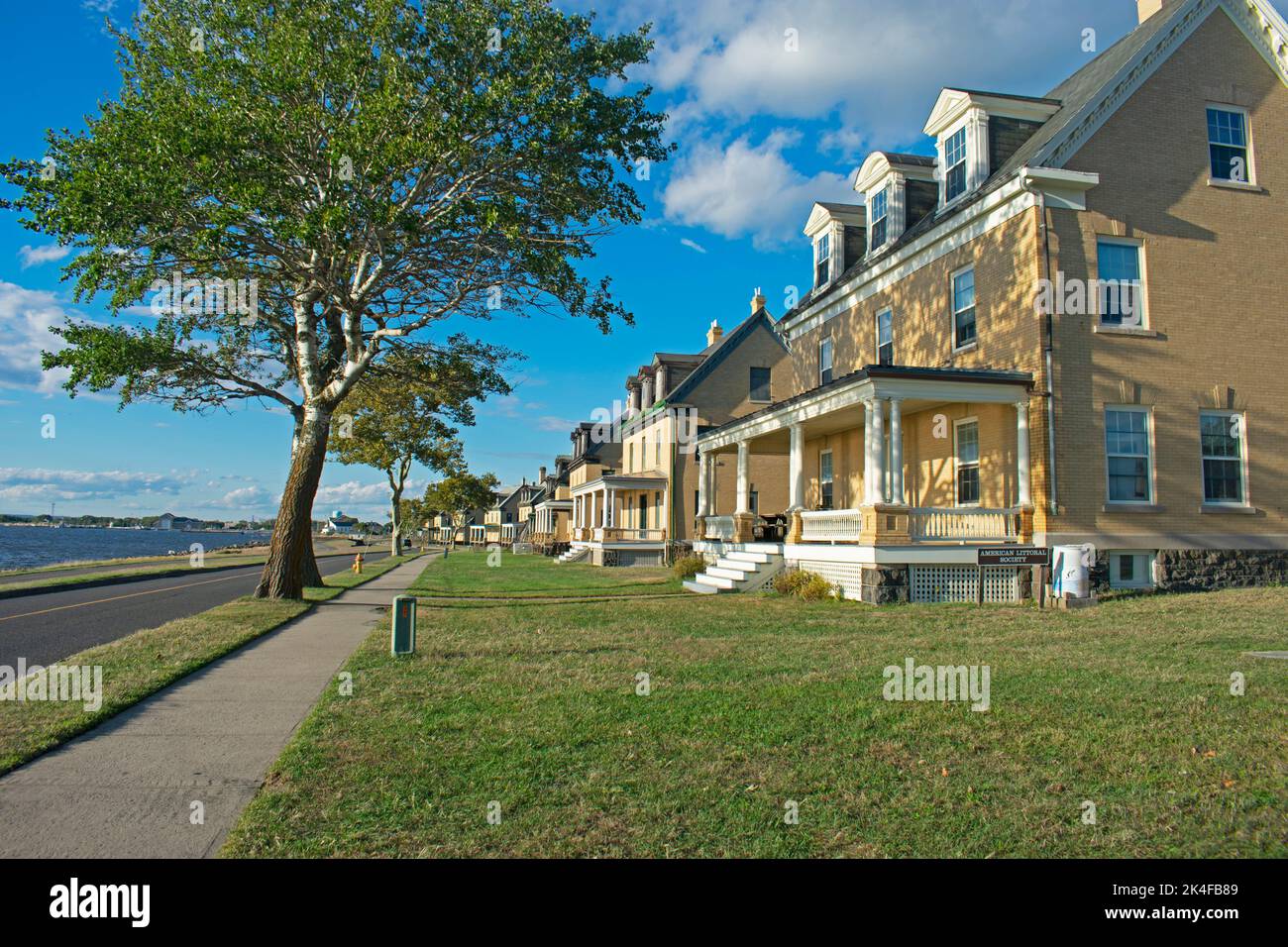 The setting sun shines on a row of damaged buildings being restored at