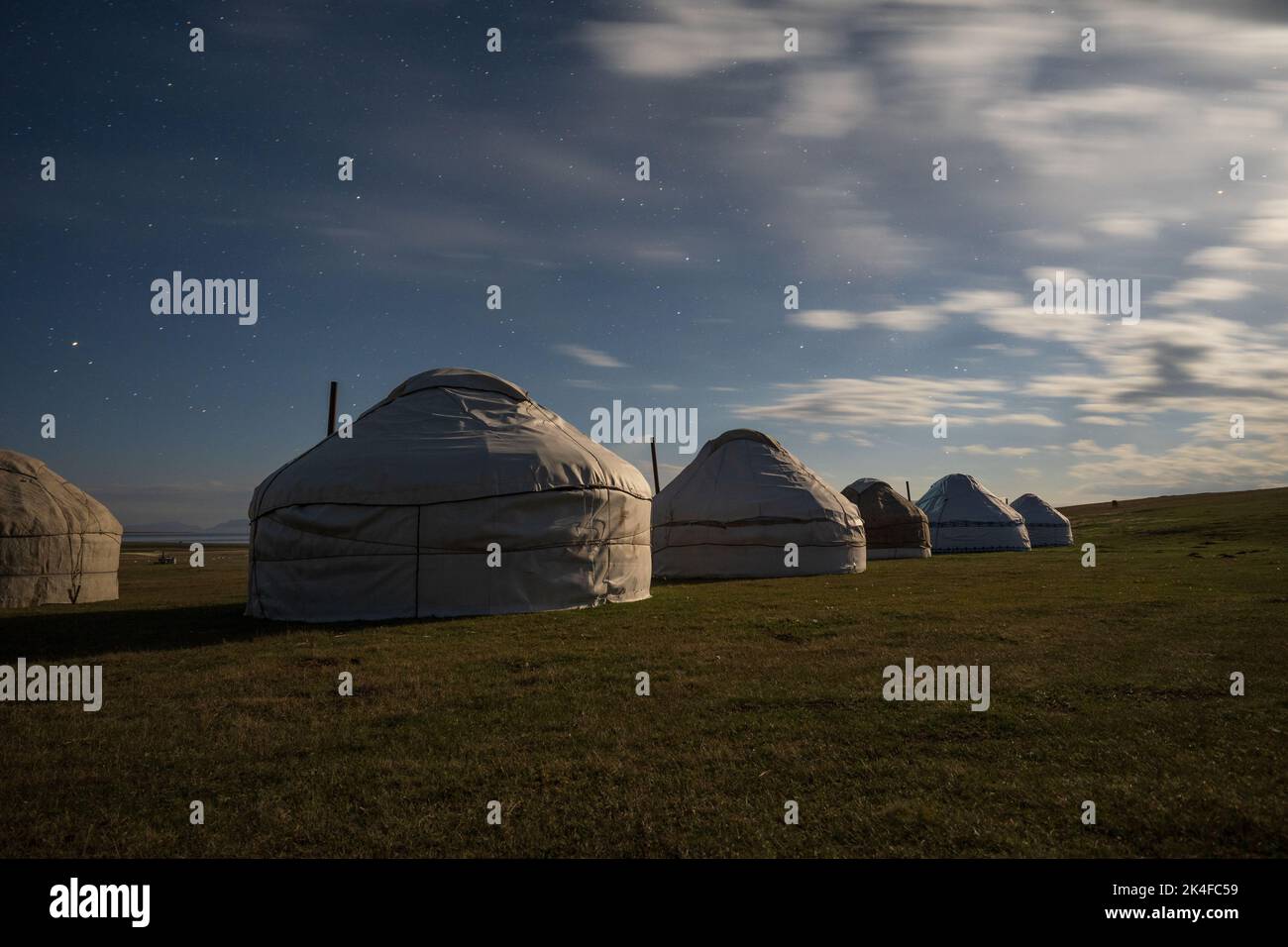 Nomadic tourist yurt camp in moonlight at night, Song Kul Lake, Kyrgyzstan Stock Photo