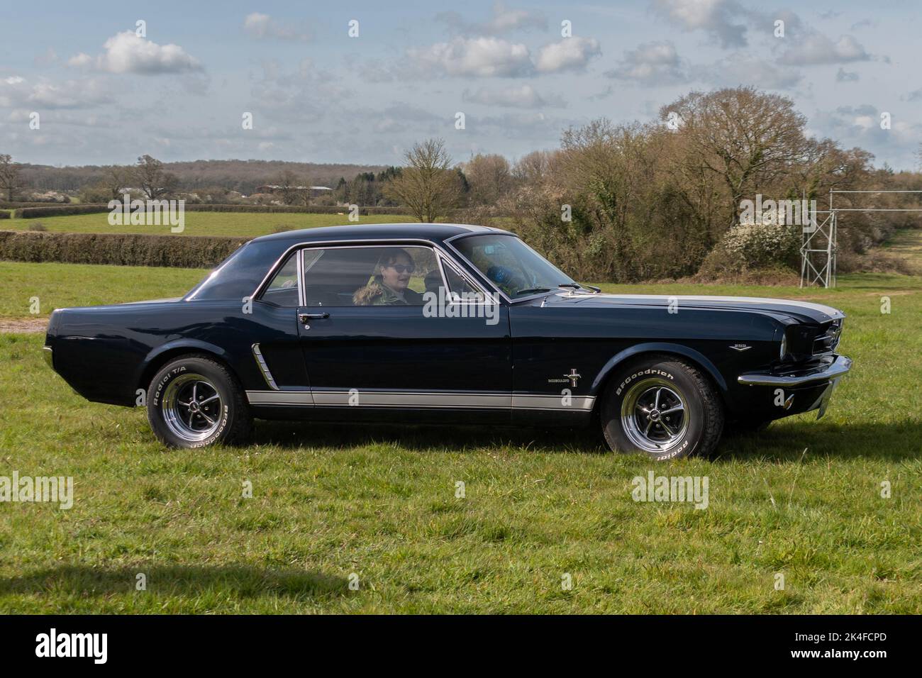 A sideways view of a 1965 4.7 litre Ford Mustang arriving to be parked ...