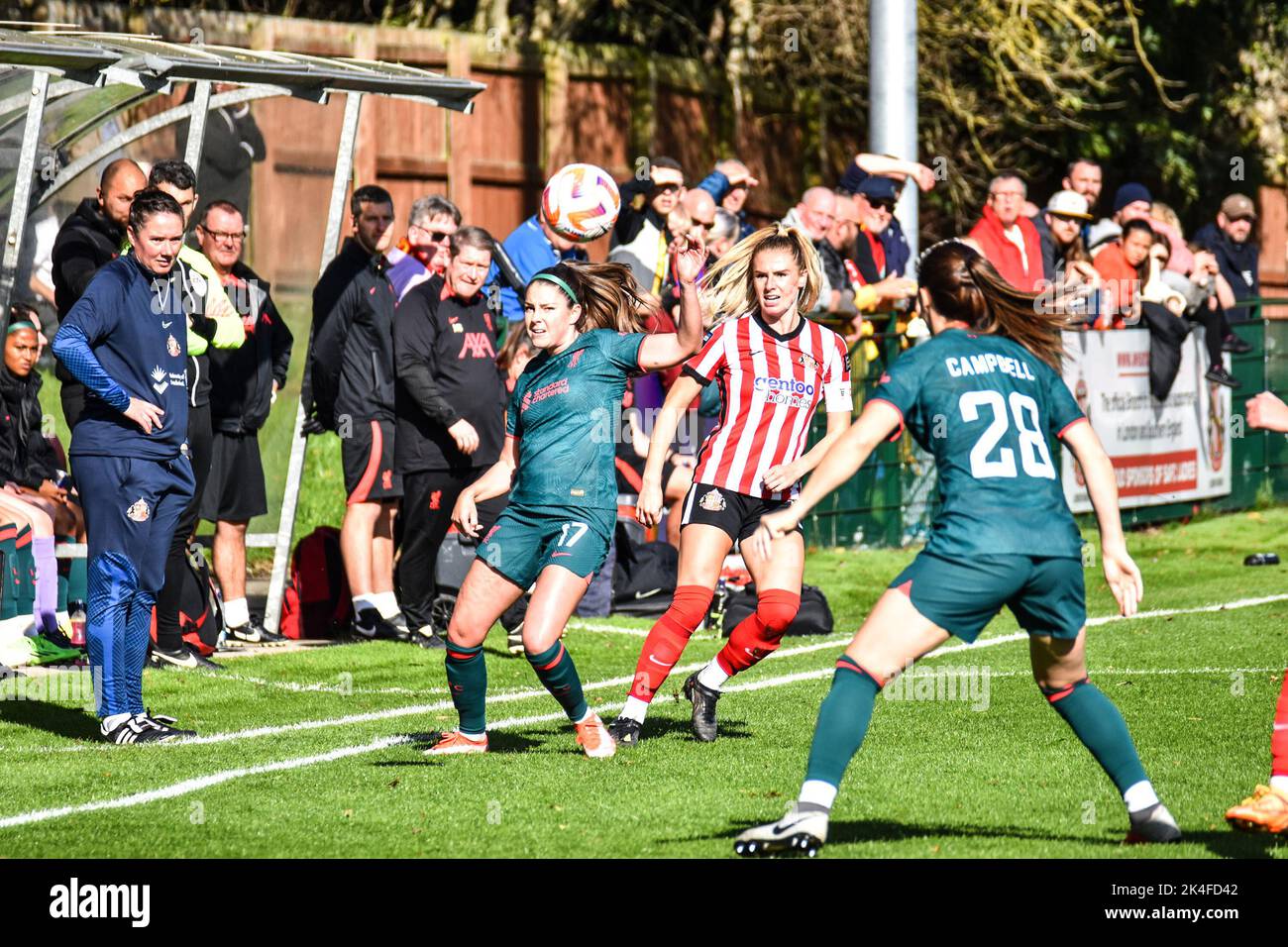 Carla Humphrey (#17) and Megan Campbell (#28) look on as Sunderland Women captain Emma Kelly passes the ball into the Liverpool Women half. Stock Photo