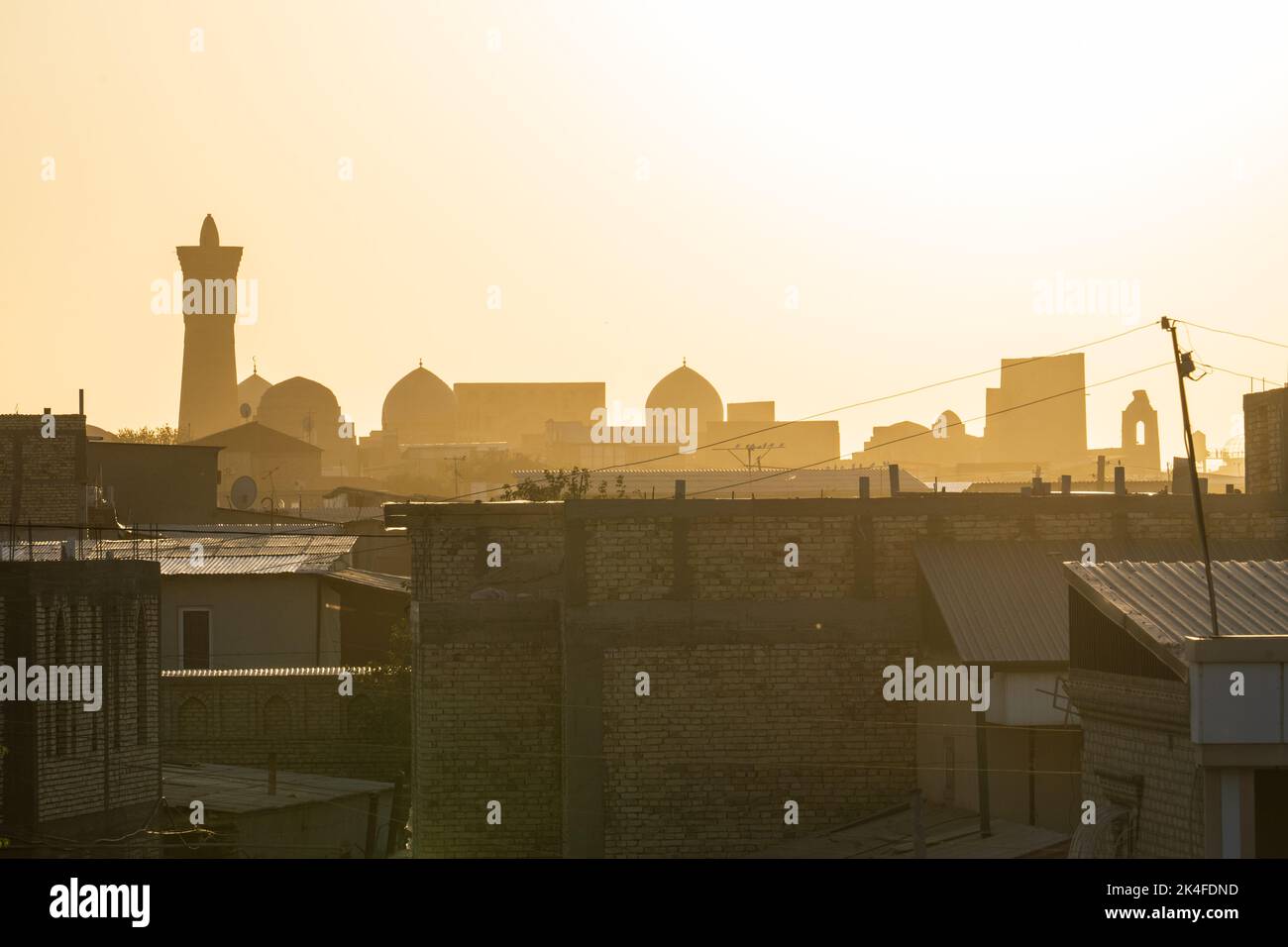 Sunset silhouettes of Bukhara main square, Kalan Mosque, Kalon Tower and Mir-i-Arab Madrasa, from Chor Minor Madrassah roof Stock Photo