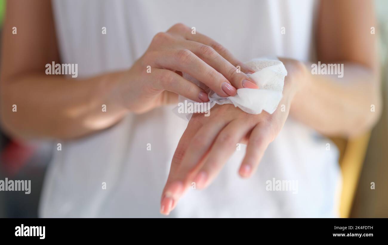 Right hand wipes left hand with piece of damp cloth closeup Stock Photo