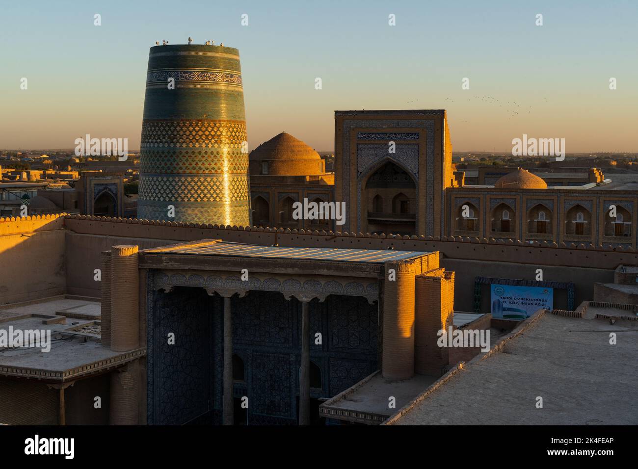 Khiva old town Kalta Minor minaret and city walls seen from Kuhna Ark fortress at sunset Stock Photo