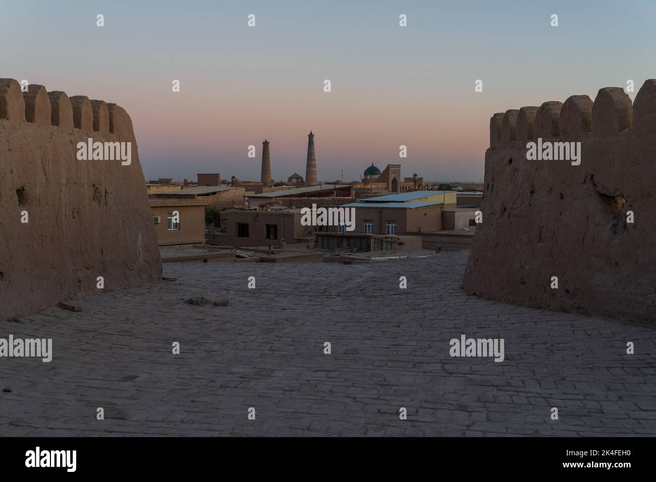 View onto Khiva old town from city wall ramparts at dusk Stock Photo