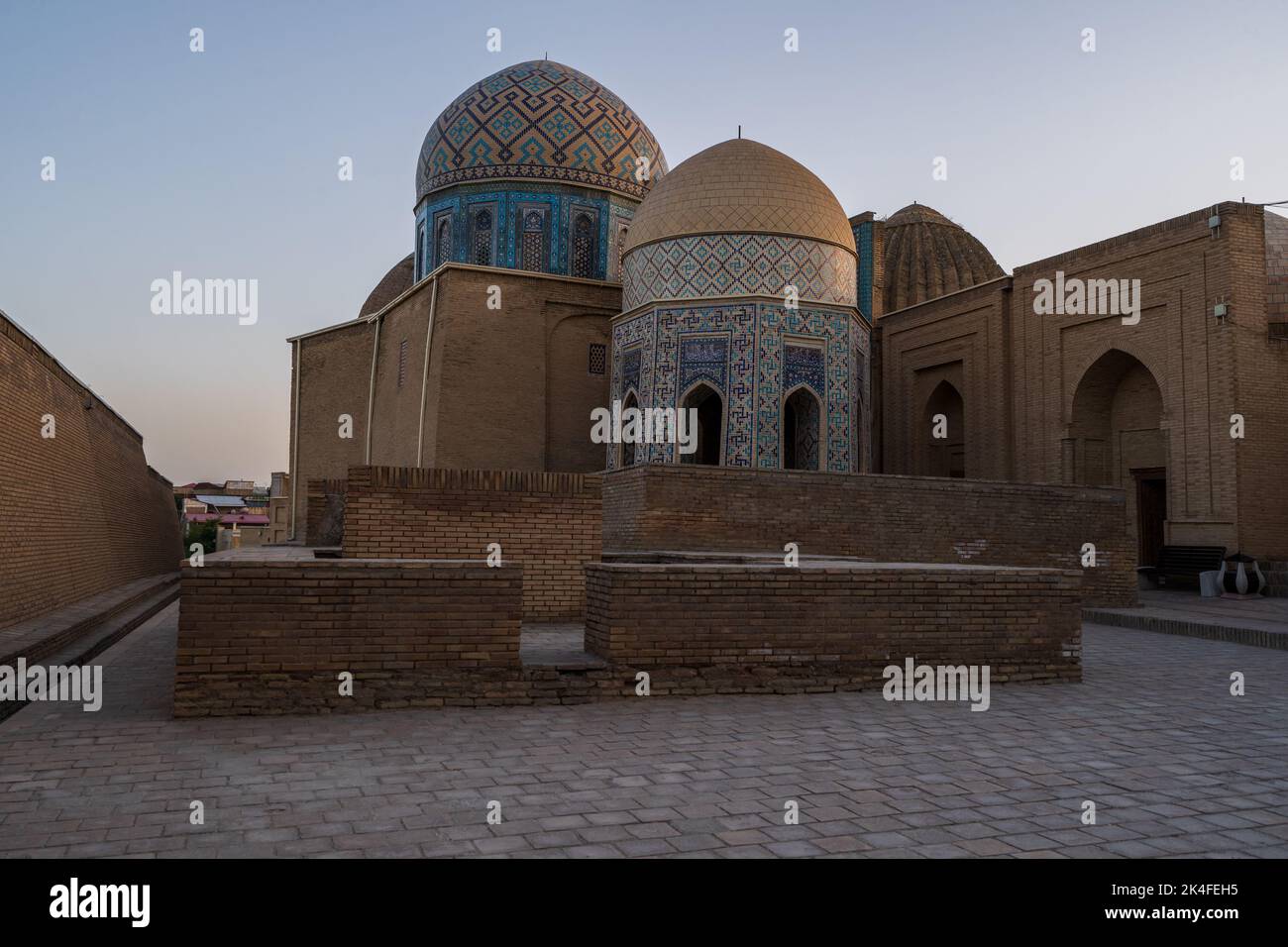 The blue tiled facades domes and arches of the Shah-i-Zinda mausoleum complex at sunset, Samarkand with very few or no people. Stock Photo
