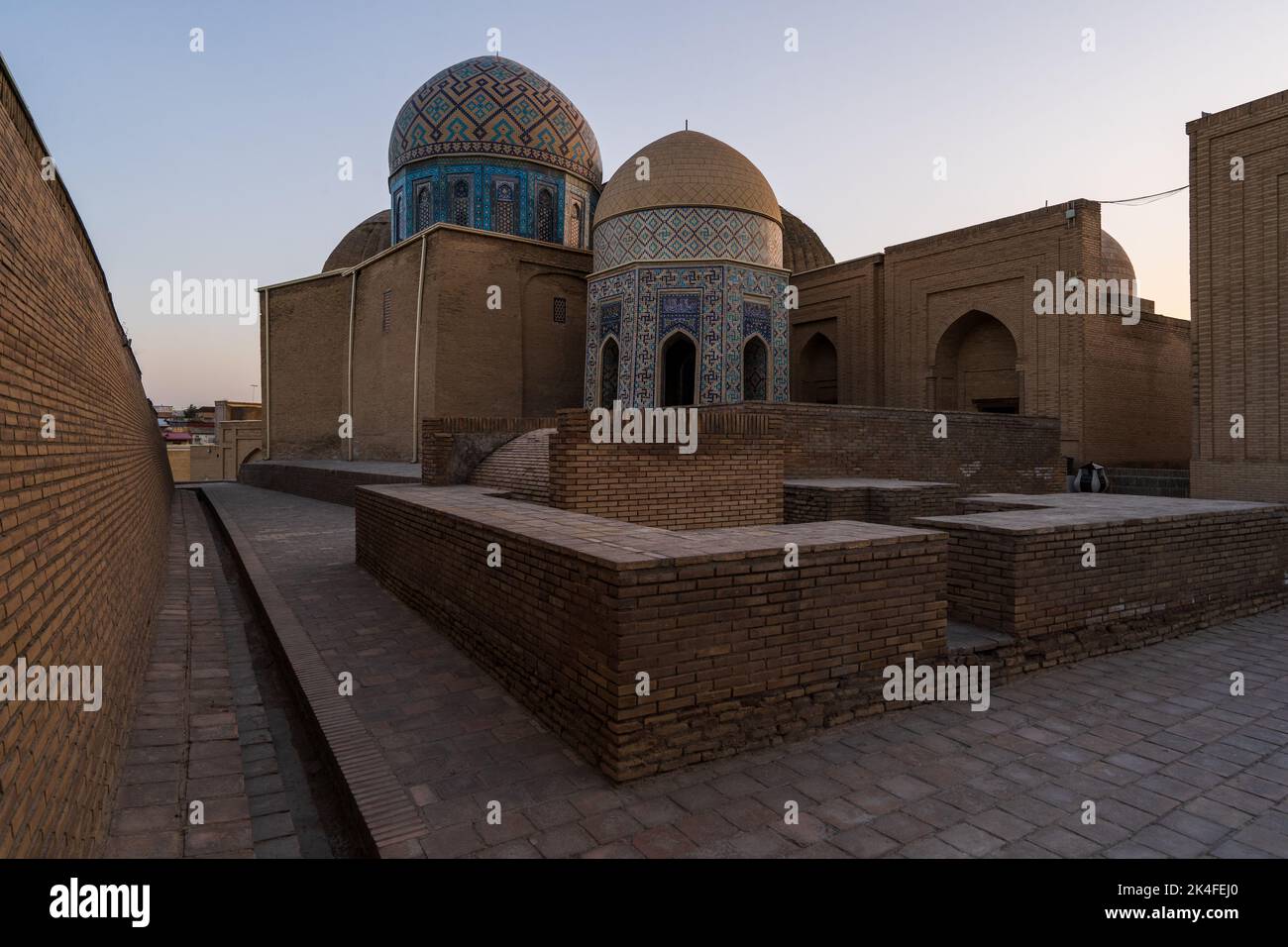 The blue tiled facades domes and arches of the Shah-i-Zinda mausoleum complex at sunset, Samarkand with very few or no people. Stock Photo