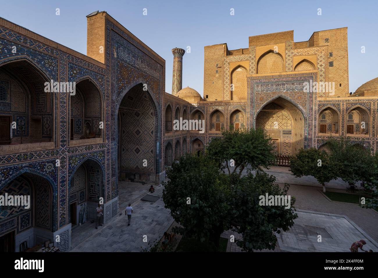 Inner courtyard of Ulugh Bek Madrassa, shot from the second floor during sunset with rays of light hitting the tops, Samarkand Stock Photo