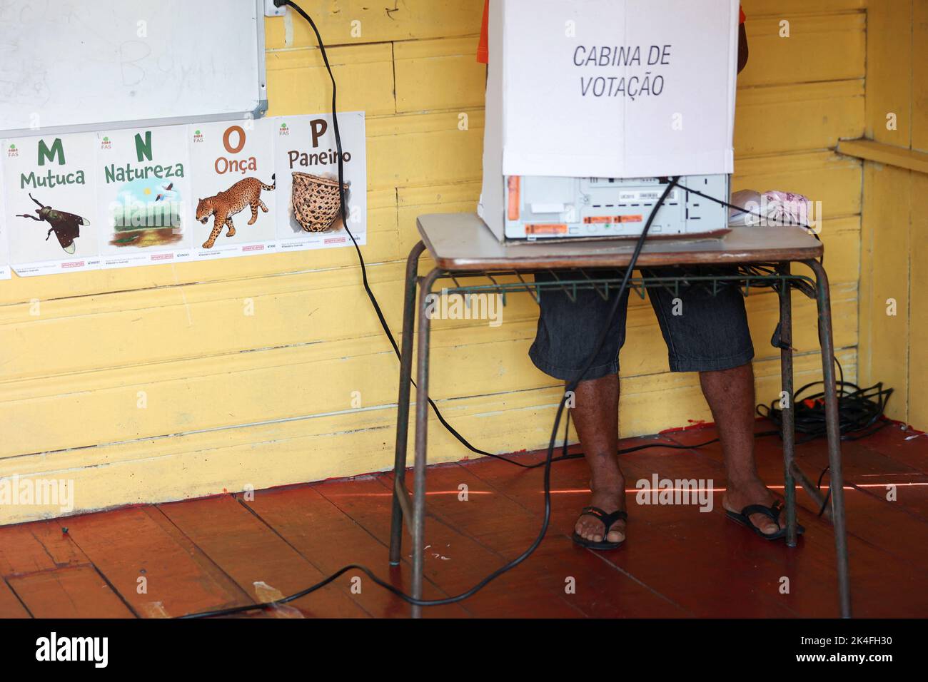 A man casts his vote at a polling station set up on a floating school on the Negro river, in the Catalao Community, Brazil October 2, 2022. REUTERS/Bruno Kelly Stock Photo