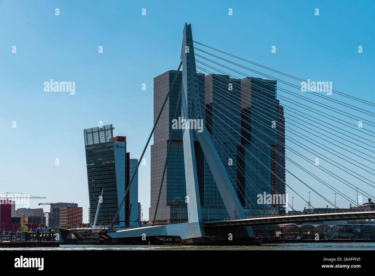 Rotterdam, Netherlands - May 8, 2022: De Rotterdam Skyscraper designed by Rem Koolhaas architect and Erasmusbrug bridge against sky. Contemporary arch Stock Photo