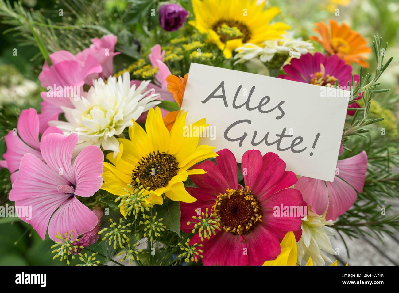 Colorful bouquet of summer flowers with a greetings card and German