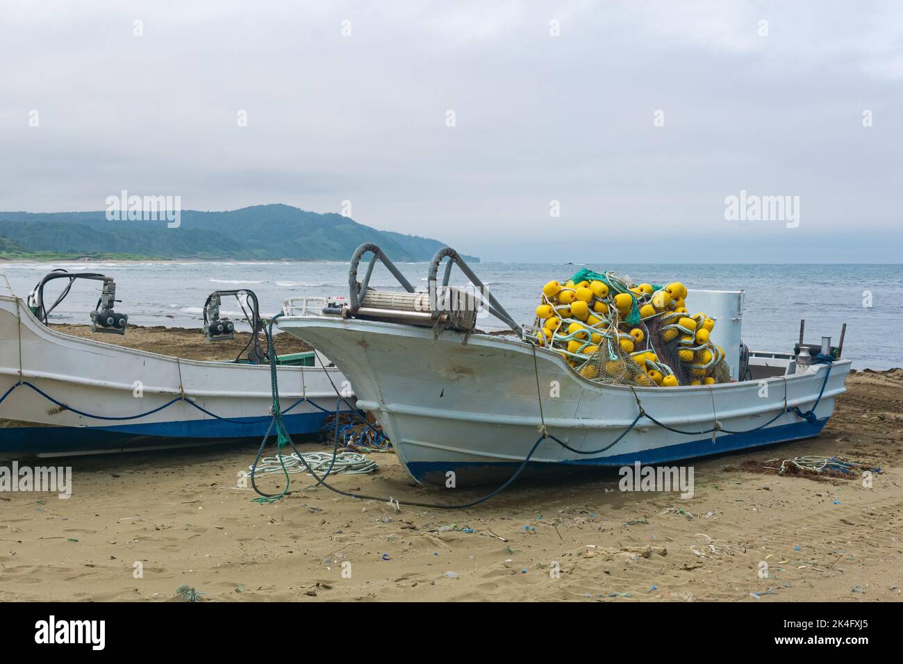 Fishing net with yellow floats dries on the pier, close-up