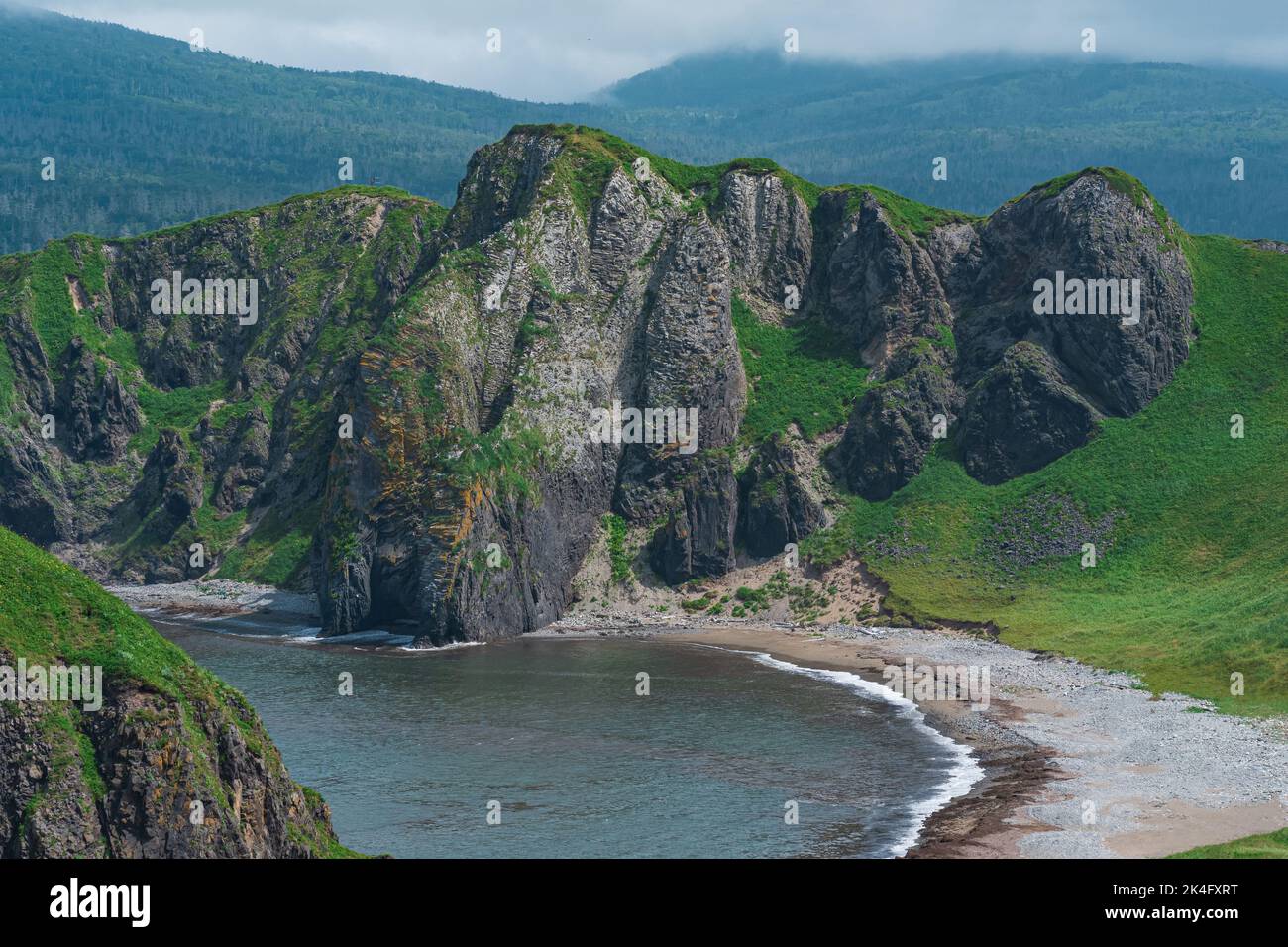 coastal landscape, wild bay with sandy beach between basalt rocks Stock Photo