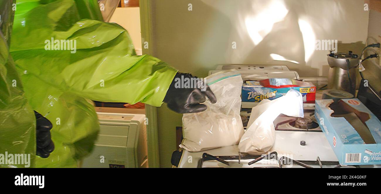 A law enforcement Fentanyl Response Team - in a HAZMAT suit handles  the drug Fentynal at a drug manufacturing site Stock Photo