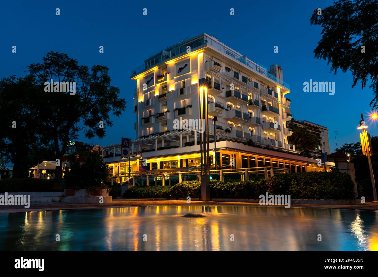 Beautiful modern hotel from the outside with balconies at night. Modern residential flat apartment building exterior. Stock Photo