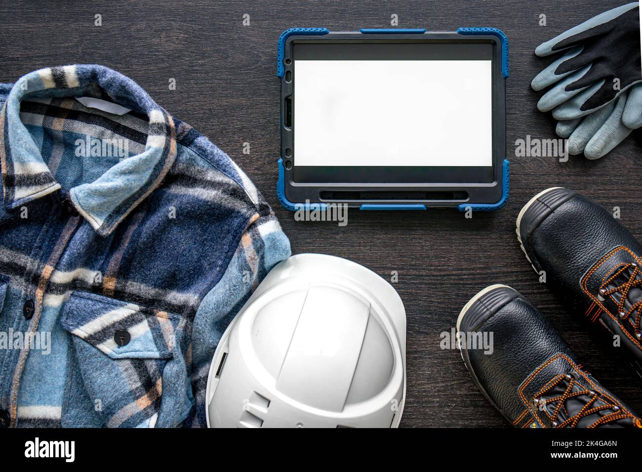 Digital tablet with layout and worker clothes, top view. Stock Photo