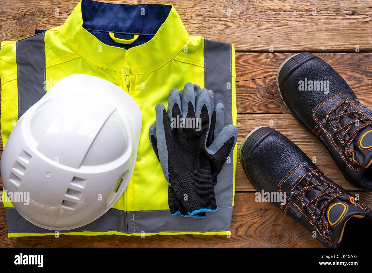 Builder uniform on wooden background, flat lay. Stock Photo
