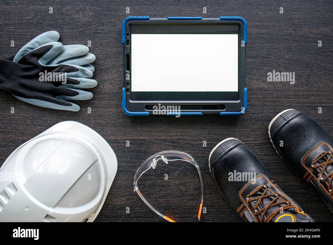 Digital tablet with layout and worker clothes, top view. Stock Photo