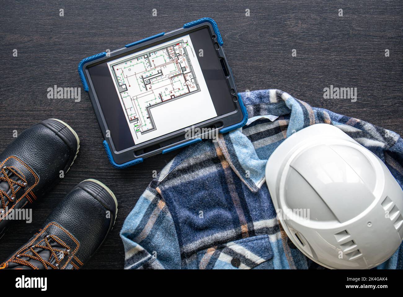 Digital tablet with layout and worker clothes, top view. Stock Photo