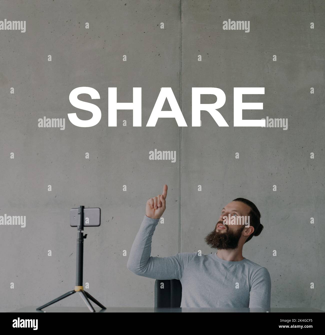 Share content. Digital influence. Social media marketing. Multimedia content promotion. Male vlogger recording video blog on smartphone pointing up sh Stock Photo