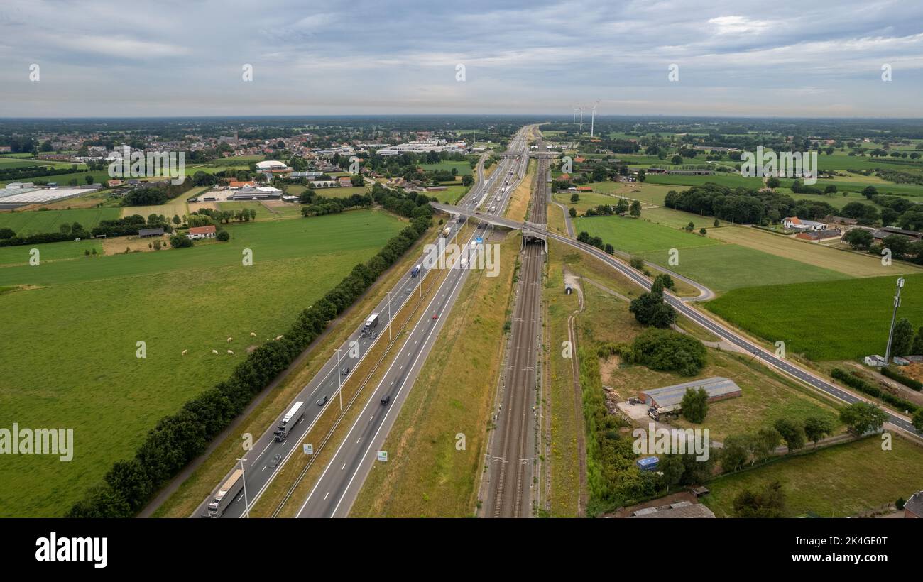 Brecht, Belgium, 6th of July, 2022, Panoramic aerial drone view of wind farm or wind park, with high wind turbines for generation electricity with the motorway with few cars and railroad next to it, near the exit of Brecht in Belgium, Europe. High quality photo Stock Photo