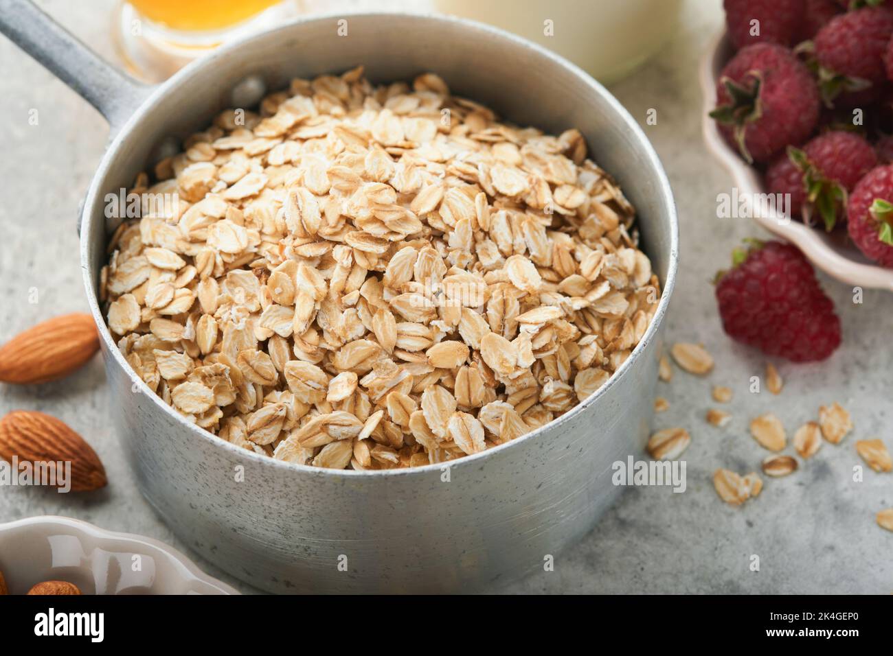 Ingredients for cooking oatmeal or granola with oats, milk, raspberries