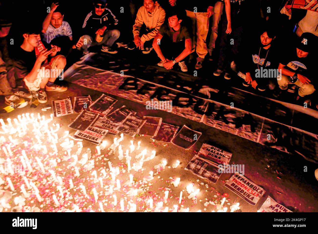 Indonesian football fans light candles in memory of the football riot