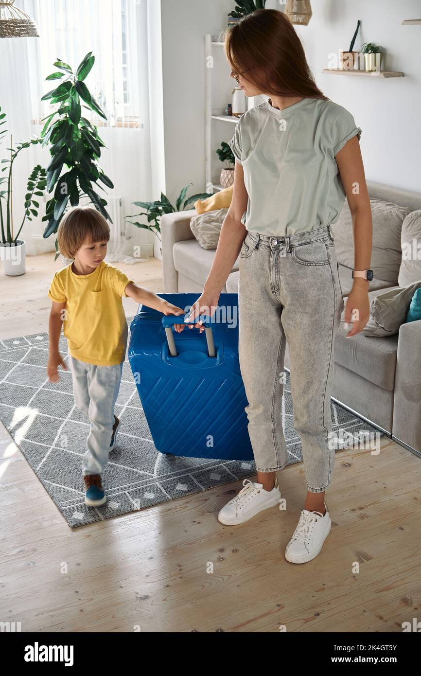 Mother and child with a suitcase are forced to leave their home. Family