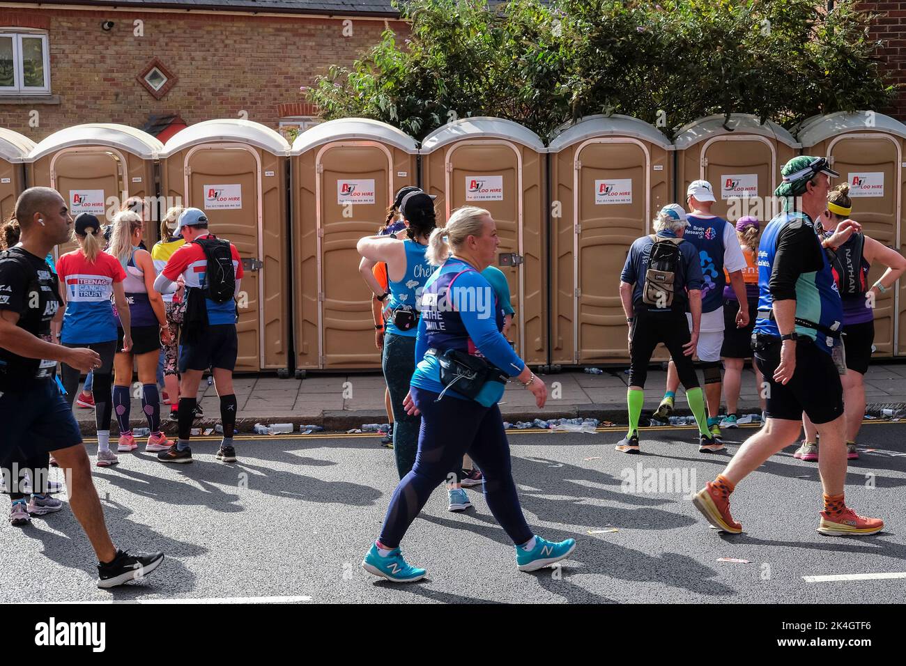 London UK, 2nd October 2022.  Participants queue to use portable toilets during the London Marathon. More than 40,000 participants take to the streets of the capital for the 42nd London Marathon. The event which attracts elite runners and wheelchair athletes also raises millions of pounds for charity through the participation of club and fitness runners along with those just wanting to take on the 26 mile challenge. Stock Photo