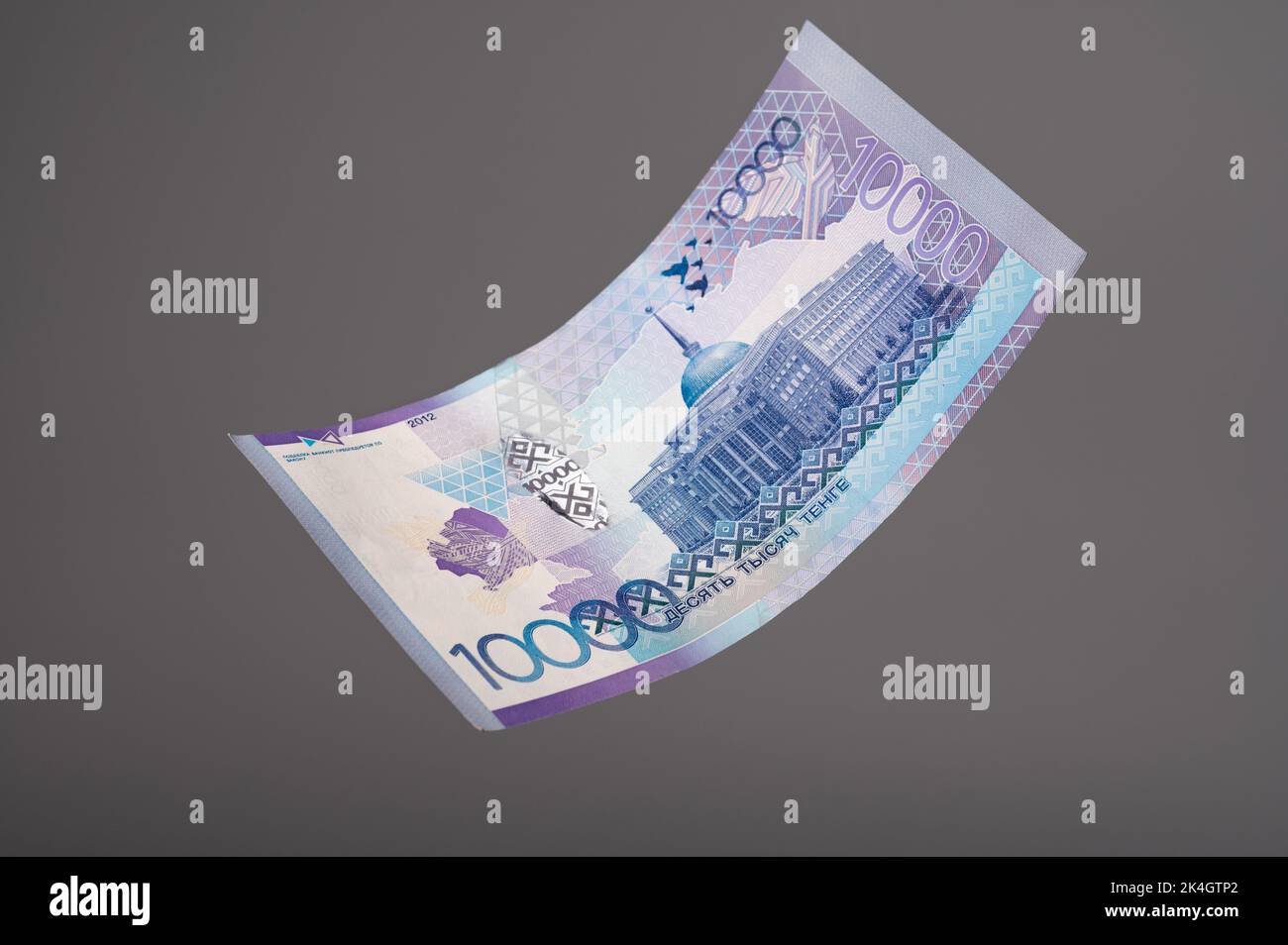 10000 banknote. Kazakhstan money - tenge. Close up of flying tenge on grey background. Stock Photo