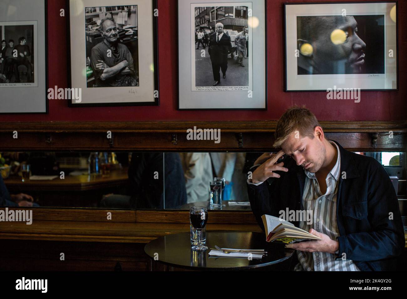 Man is reading a book in pub ,French House pub in Soho , Soho ,London ,England , UK Stock Photo