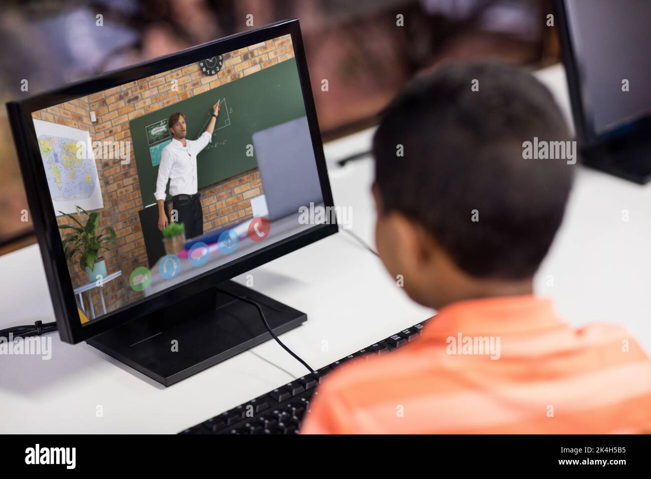 Male student having a video call with male teacher on computer at ...