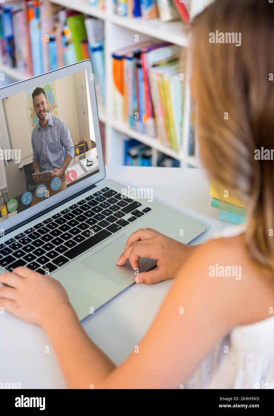 Female student having a video call with male teacher on laptop at the ...