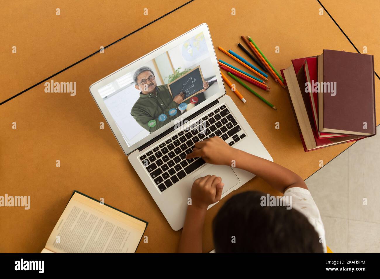 Overhead view of male student having a video call with male teacher on ...