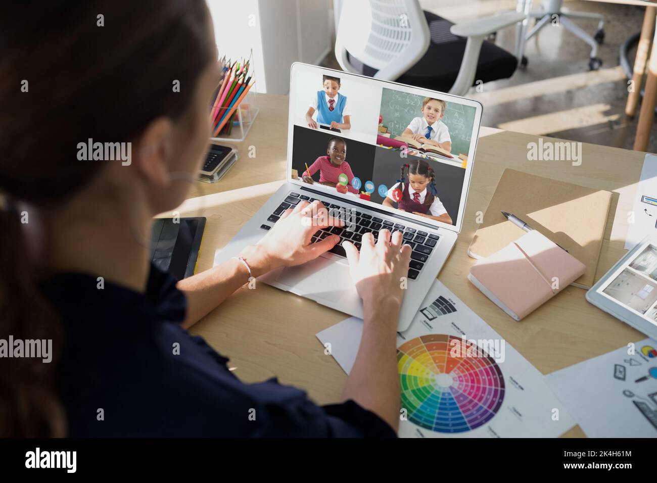 Female teacher having a video conference with multiple students on ...