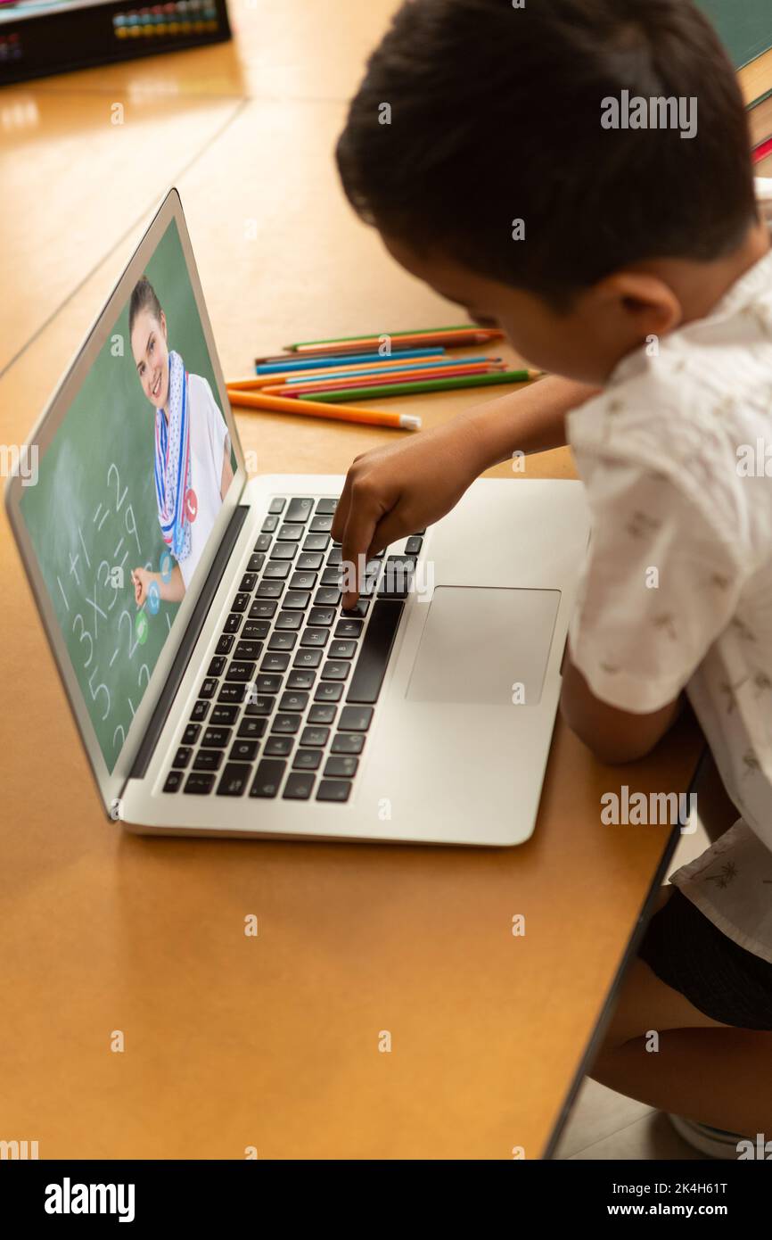 Male student having a video call with female teacher on laptop at ...