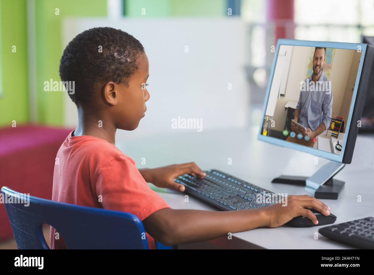 African american schoolboy using computer on video call with male ...