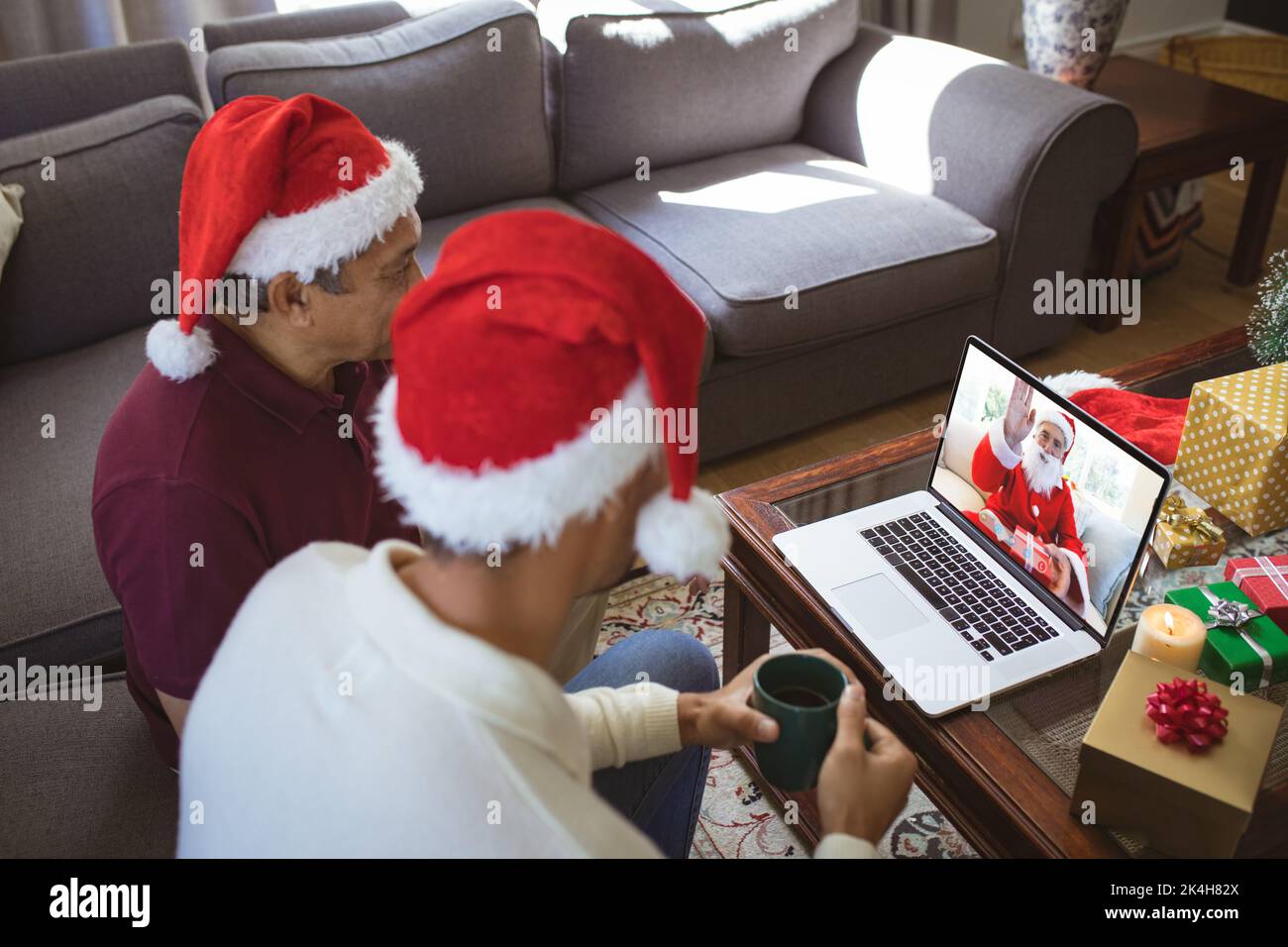 Biracial father and adult son in santa hats making laptop christmas ...