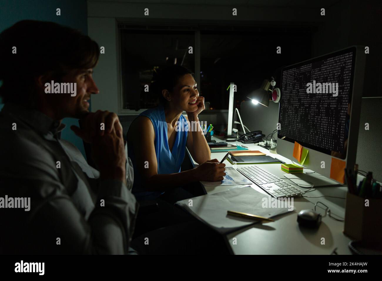 Smiling diverse male and female colleague at desk using computer with ...